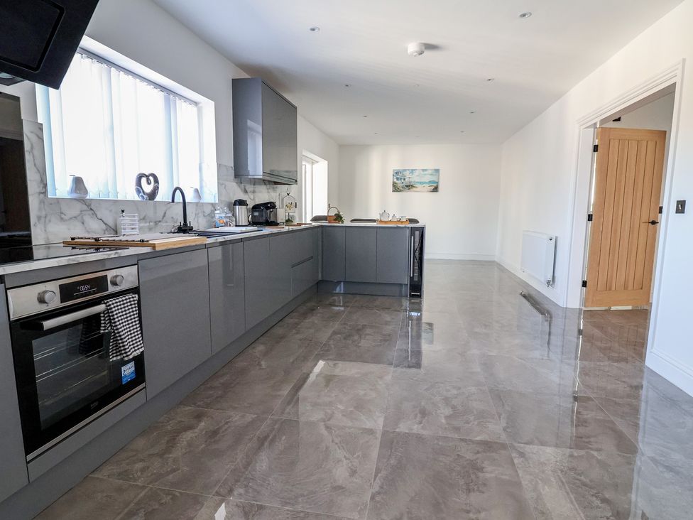A kitchen with cabinets and appliances at 1 Talbot Drive Talacre