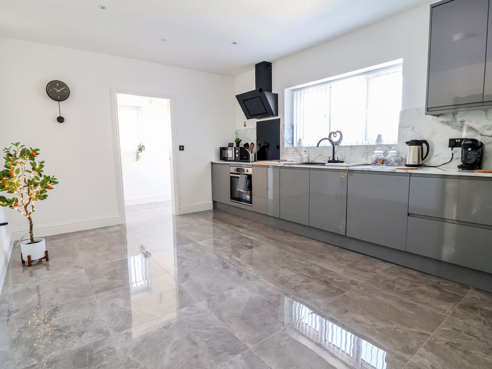 A kitchen with cabinets, appliances, and a window at 1 Talbot Drive Talacre