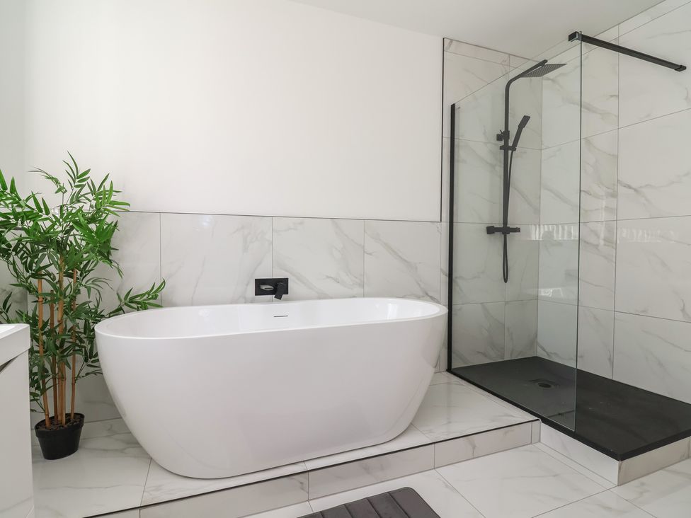 A bathroom with a bathtub and a shower at 1 Talbot Drive Talacre