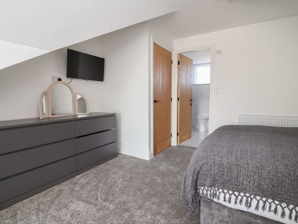 A bedroom with a dresser and television at 1 Talbot Drive, Talacre