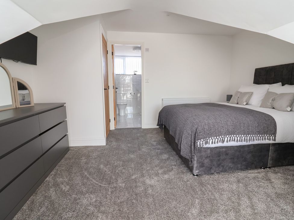 A bedroom with a bed and chest of drawers at 1 Talbot Drive Talacre