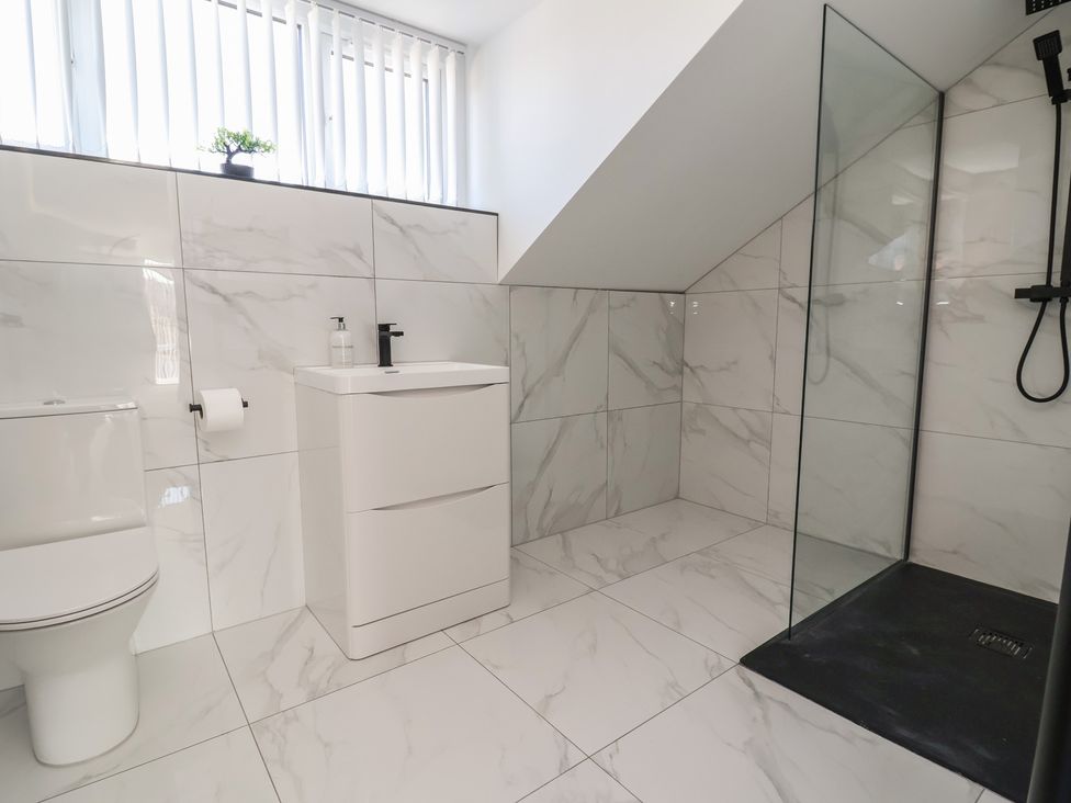 A bathroom with a shower, toilet, and sink at 1 Talbot Drive in Talacre