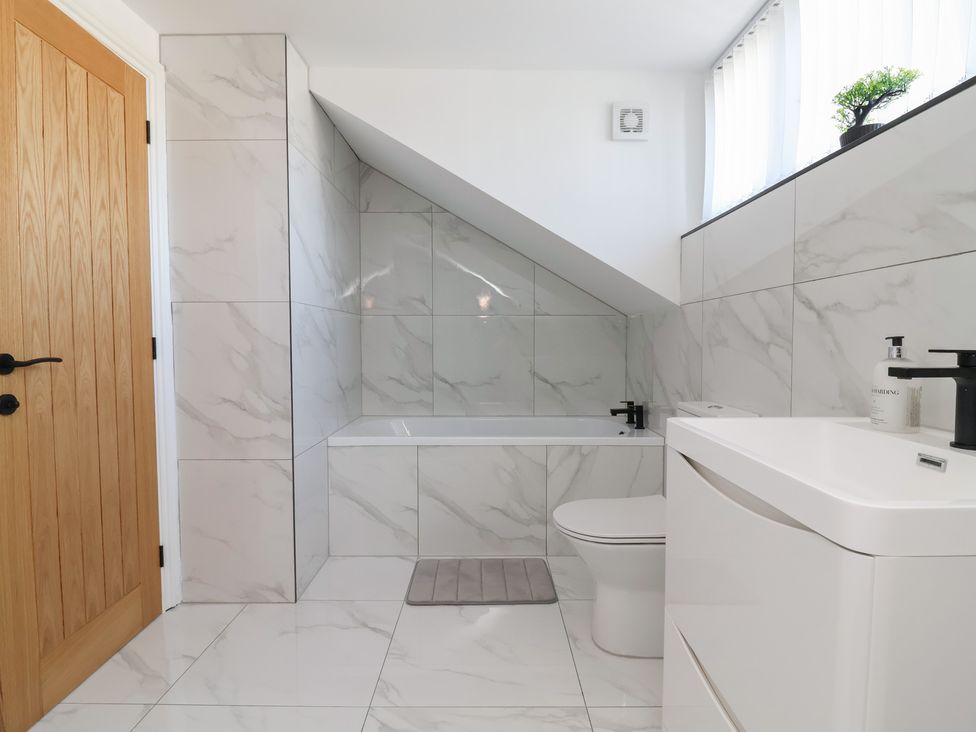 A bathroom with a bathtub, toilet, and vanity unit at 1 Talbot Drive, Talacre