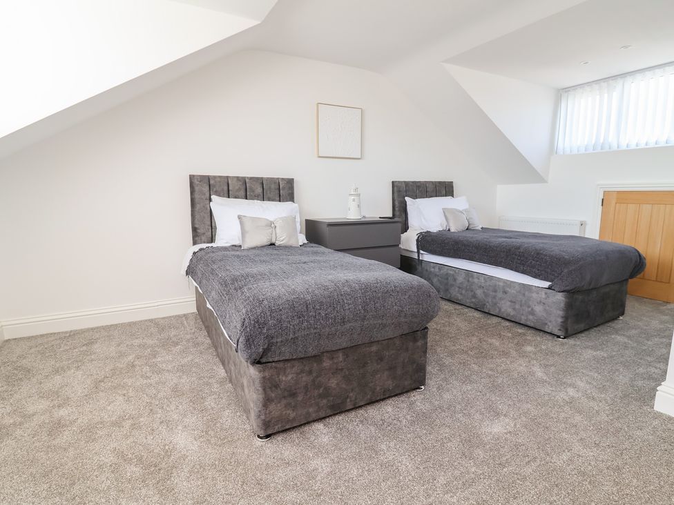 A bedroom with two single beds and a nightstand at 1 Talbot Drive Talacre