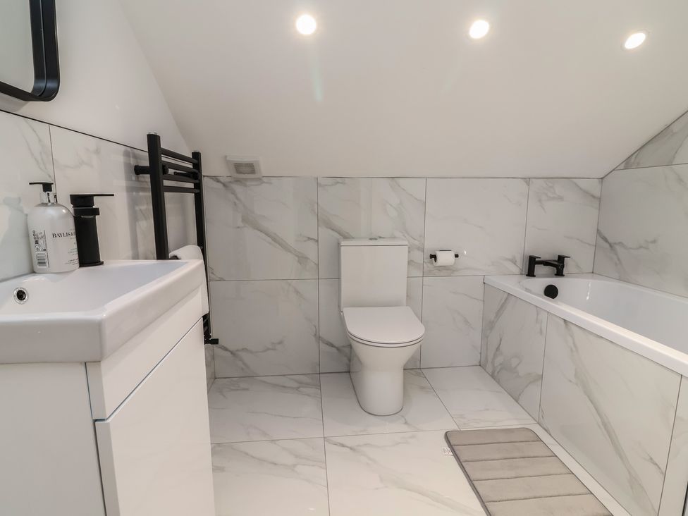 A bathroom with a sink, toilet, and bathtub at 1 Talbot Drive in Talacre