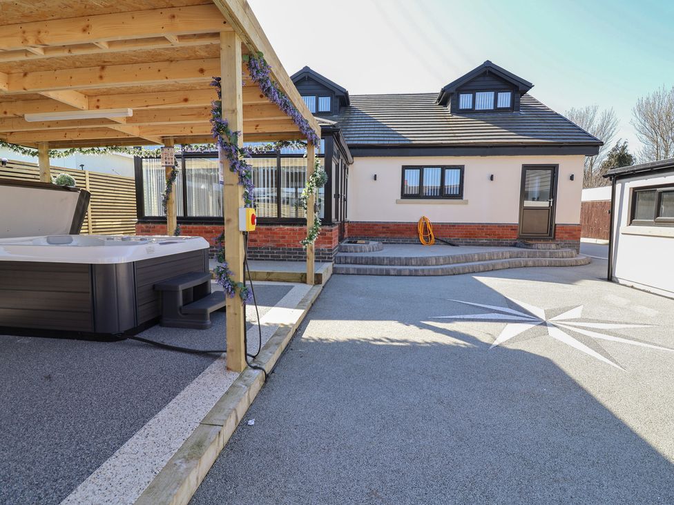 An outdoor area featuring a hot tub and a house at 1 Talbot Drive Talacre