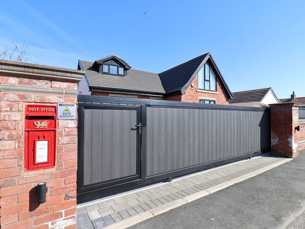An outdoor view of a gate and post box at 1 Talbot Drive in Talacre