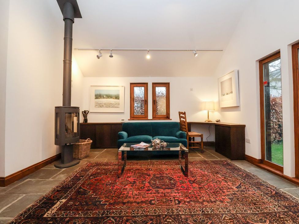A living room with a stove and sofa at Owl Cottage in Woodbridge