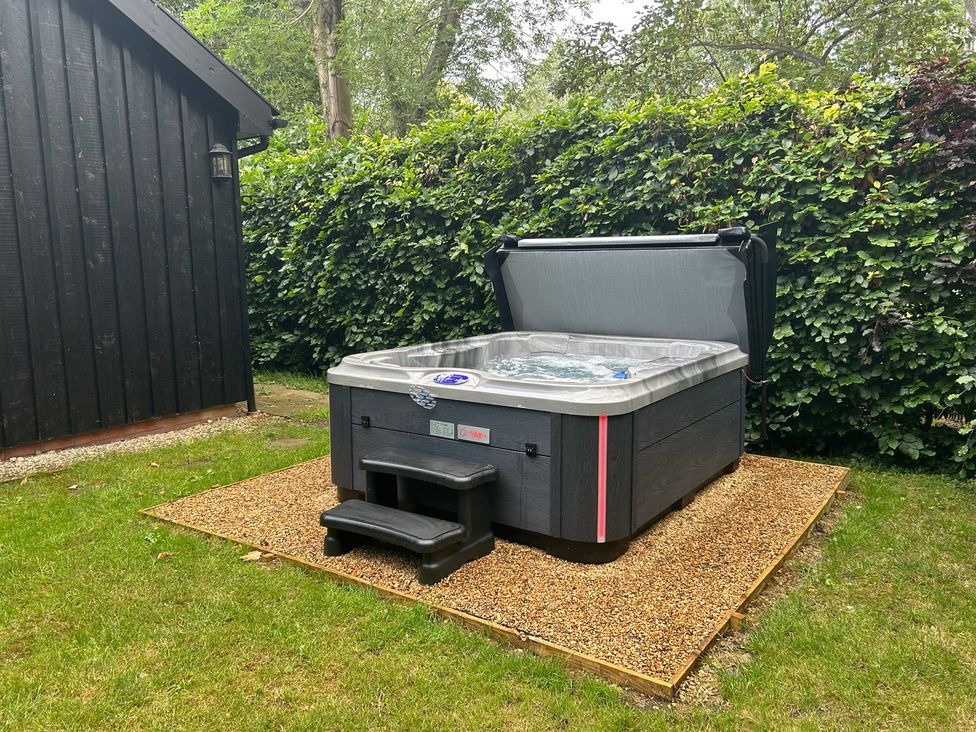 A hot tub on a gravel surface at Owl Cottage in Kettleburgh near Framlingham