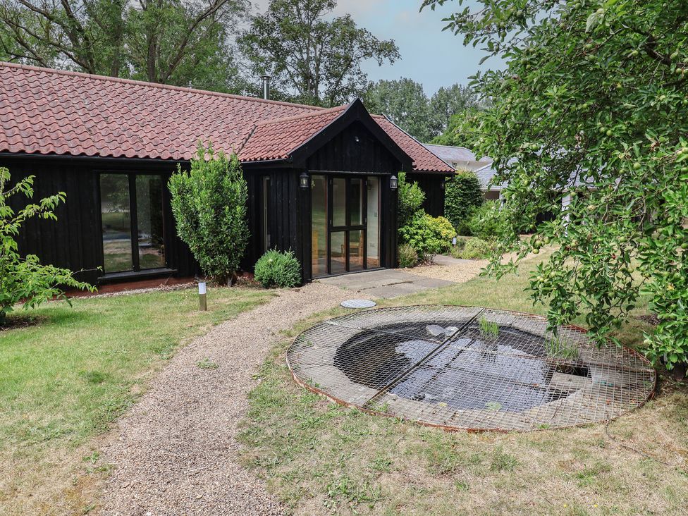 An outdoor area with a pond and a gravel path at Owl Cottage Kettleburgh near Framlingham