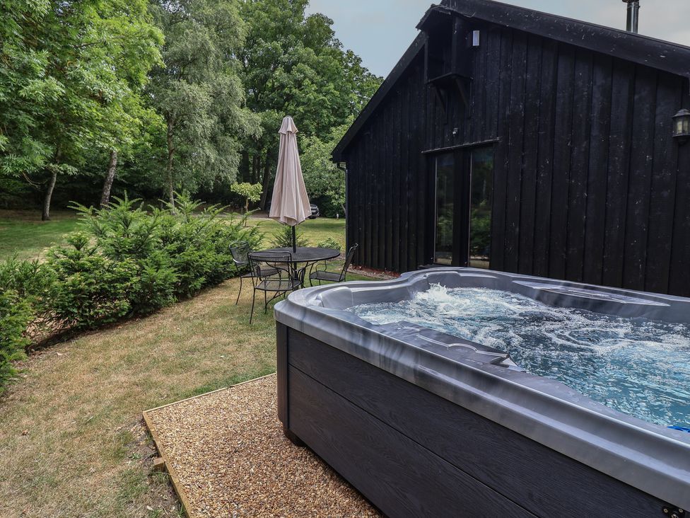 A hot tub and seating area at Owl Cottage in Kettleburgh near Framlingham