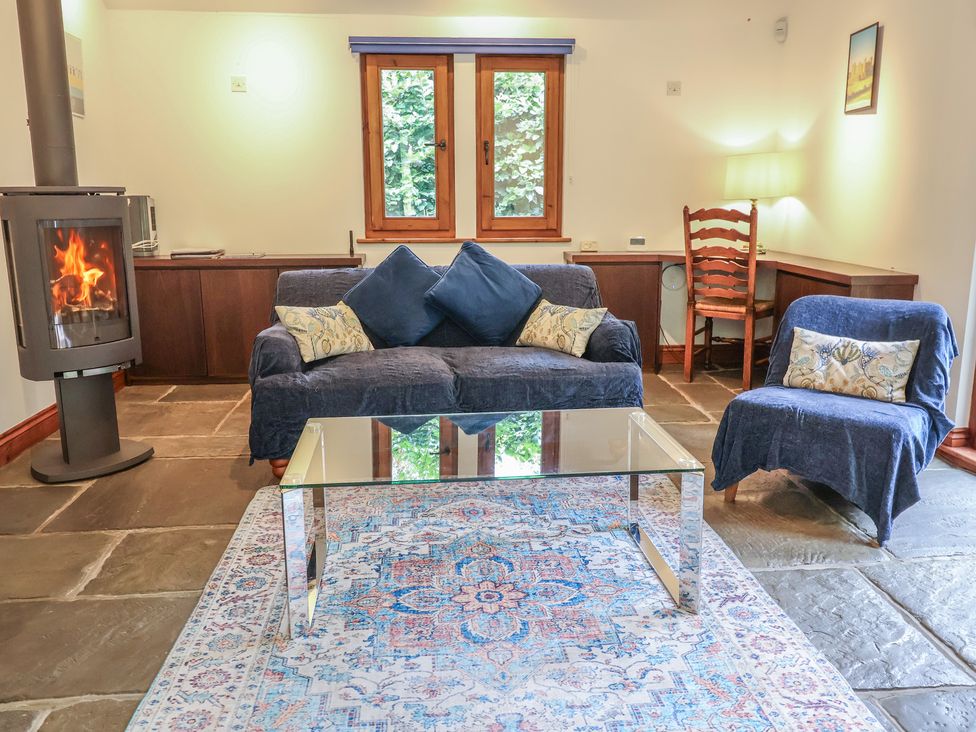 A living room with a sofa and coffee table at Owl Cottage in Kettleburgh near Framlingham