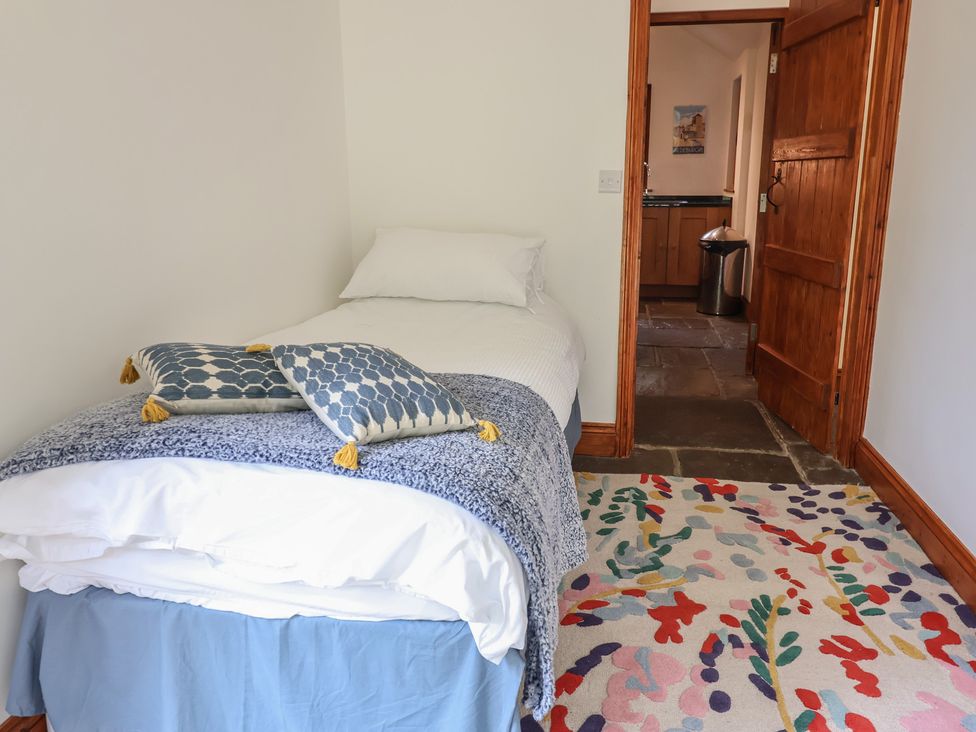 A bedroom with a bed and a door at Owl Cottage Kettleburgh near Framlingham