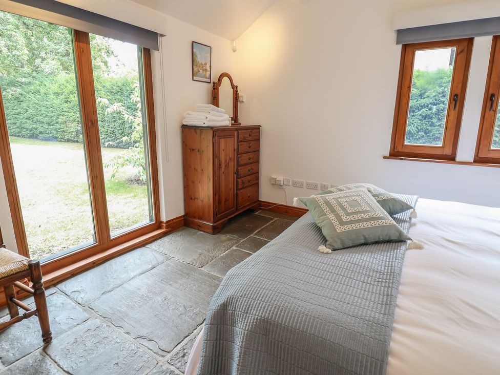 A bedroom with a bed and wooden furniture at Owl Cottage Kettleburgh near Framlingham