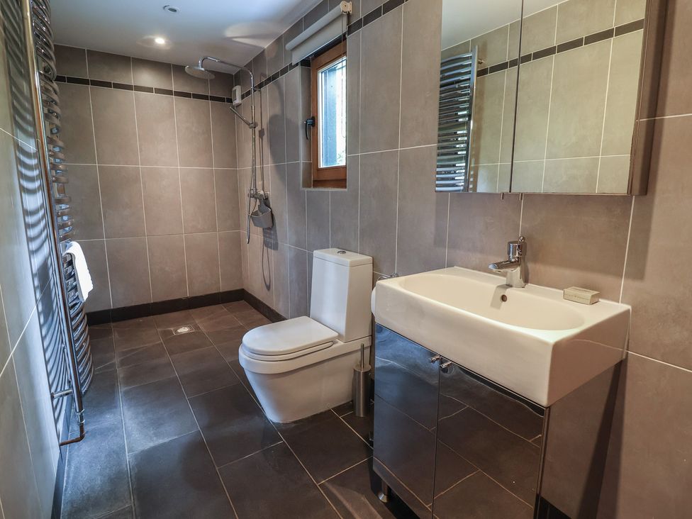 A bathroom with a shower, toilet, and sink at Owl Cottage in Kettleburgh near Framlingham