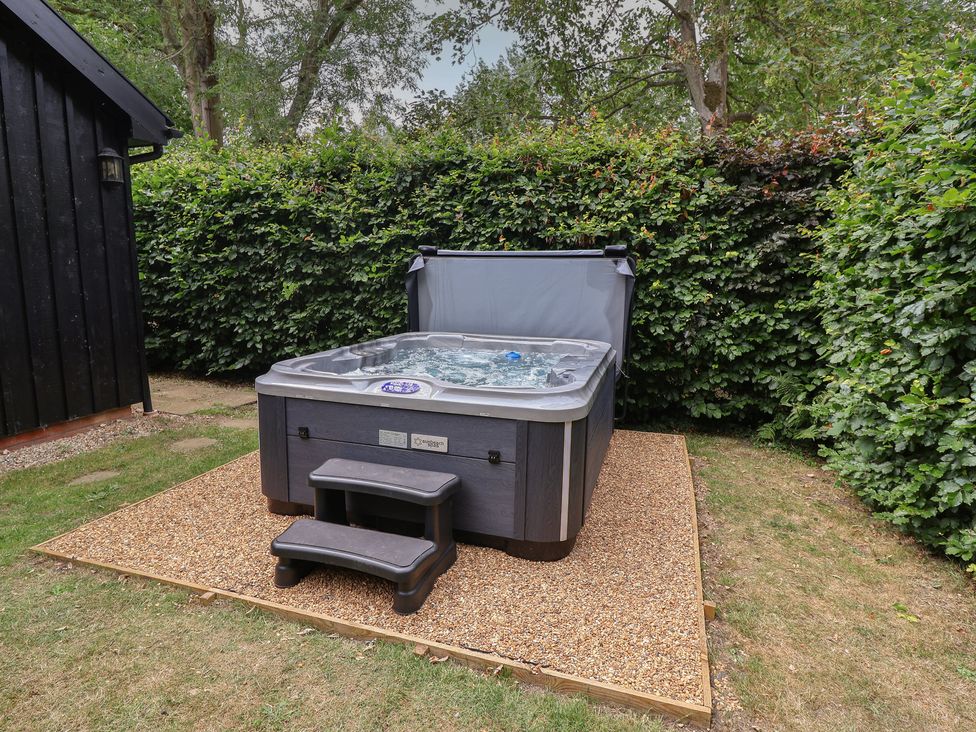 A hot tub with steps in a garden at Owl Cottage in Kettleburgh near Framlingham