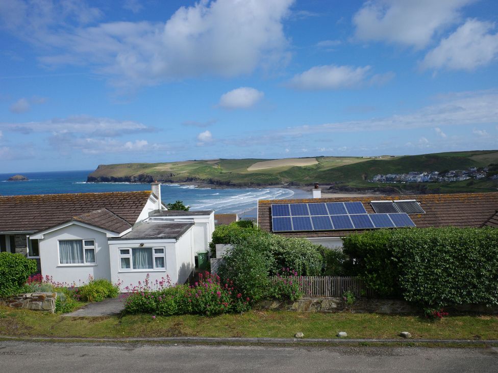 A scenic view of houses with solar panels and ocean at Badgers Cliff in Polzeath