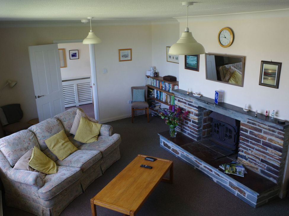 A living room with a sofa and fireplace at Badgers Cliff in Polzeath