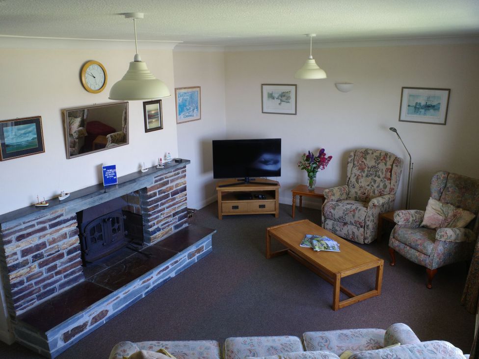 A living room with a television and fireplace at Badgers Cliff in Polzeath