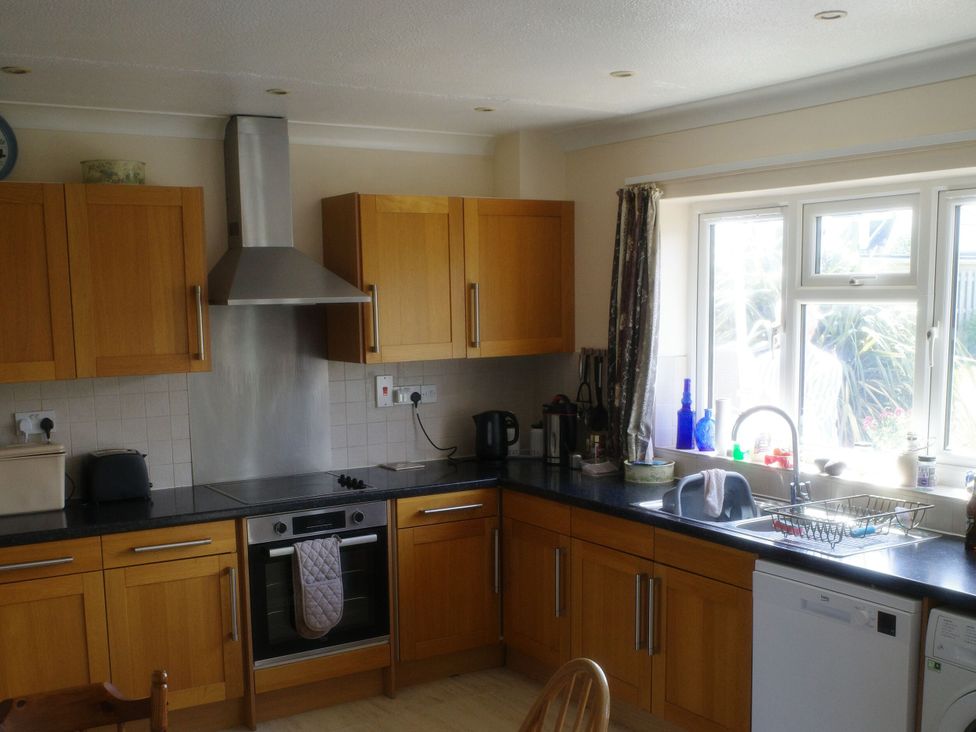 A kitchen with cabinets and appliances at Badgers Cliff in Polzeath