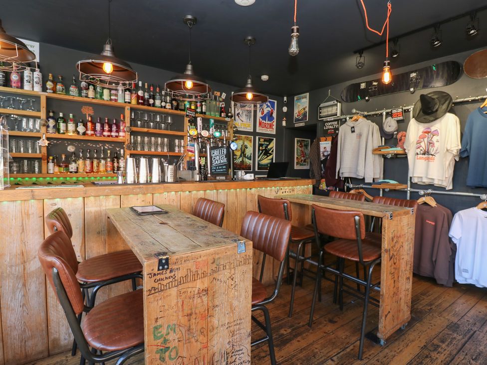 A bar with stools and bottles on shelves at Chalet 86 in North Shields