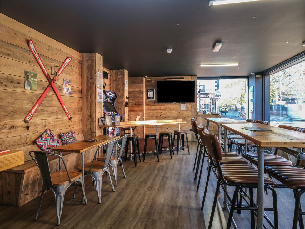 A bar with wooden decor and seating at Chalet 86 in North Shields