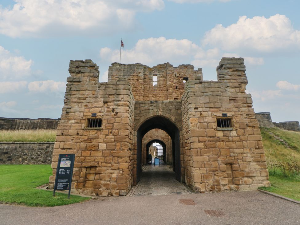 A castle entrance with stone walls and an information sign at Chalet 86 in North Shields