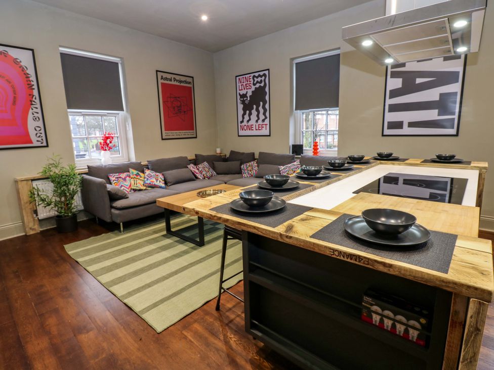 A kitchen island with bowls and a sofa in the living room at Chalet 86 Tynemouth