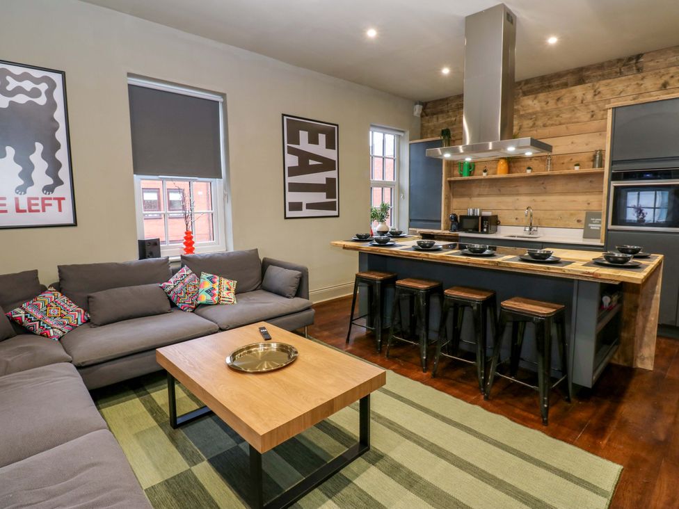 A living room with a sofa and kitchen island at Chalet 86 Tynemouth