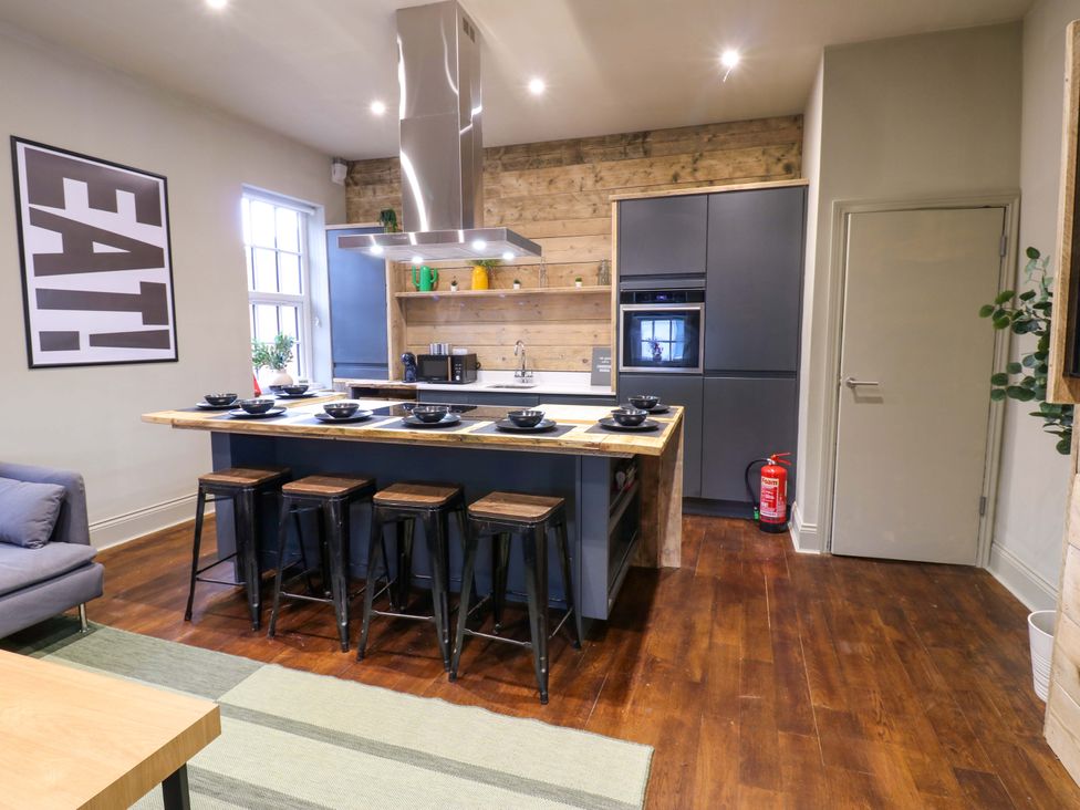 A kitchen with an island and stools at Chalet 86 Tynemouth