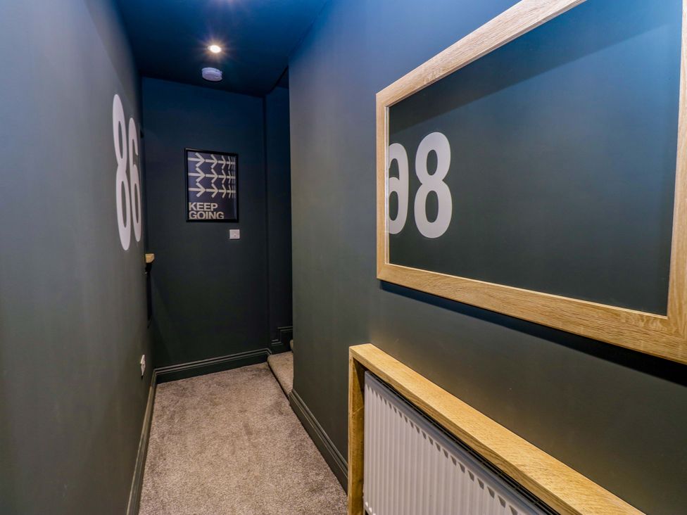 A hallway with framed numbers and a picture at Chalet 86 Tynemouth