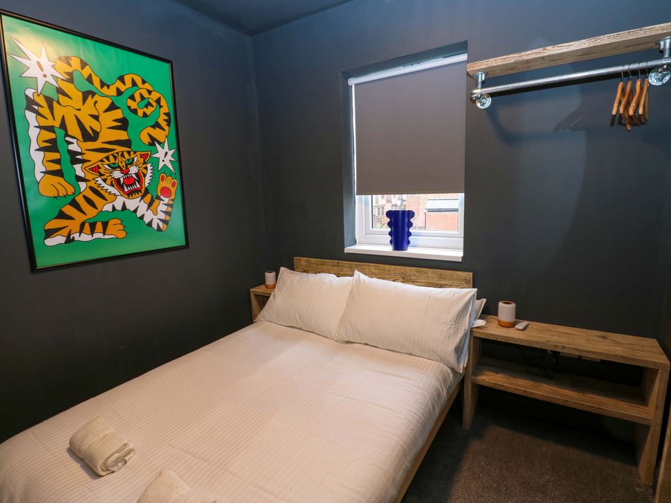 A bedroom with a bed and wall art at Chalet 86 in Tynemouth