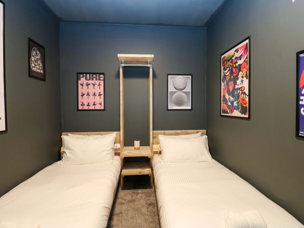 A bedroom with two single beds and wall art at Chalet 86 Tynemouth