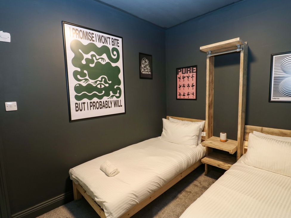 A bedroom with two beds and artwork on the wall at Chalet 86 Tynemouth