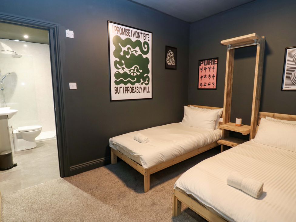 A bedroom with two beds and an adjoining bathroom at Chalet 86 in Tynemouth