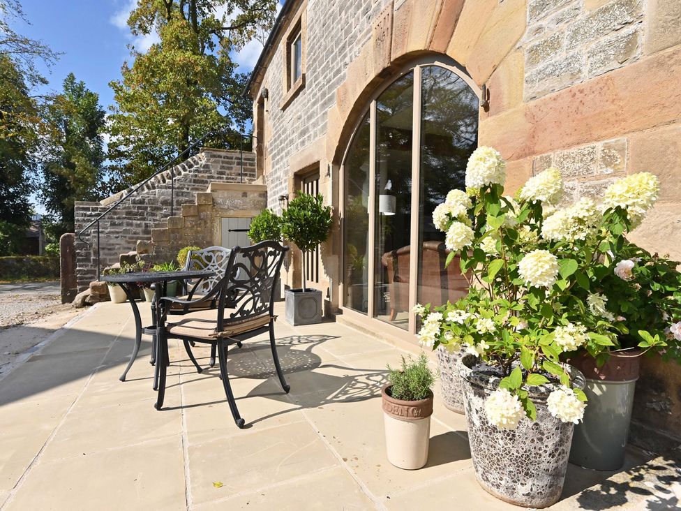An outdoor seating area with a table and chairs at Lane House Farm Barn Butterton