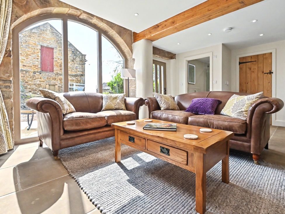 A living room with sofas and a coffee table at Lane House Farm Barn Butterton