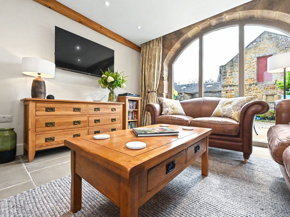 A living room with a sofa and coffee table at Lane House Farm Barn Butterton