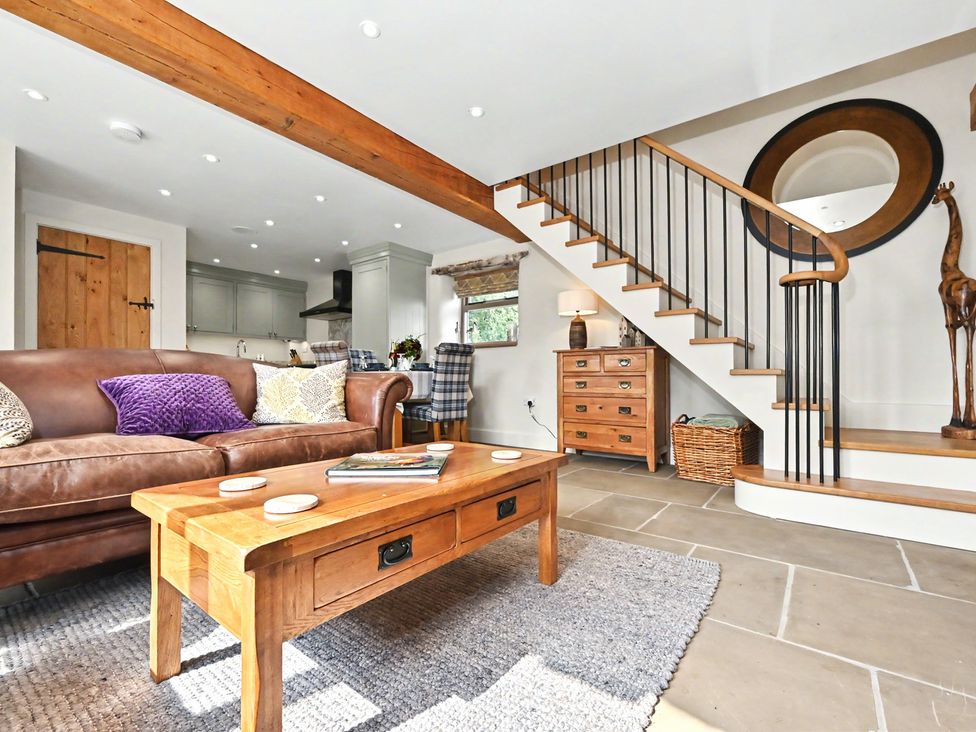 A living room with a sofa and coffee table at Lane House Farm Barn Butterton