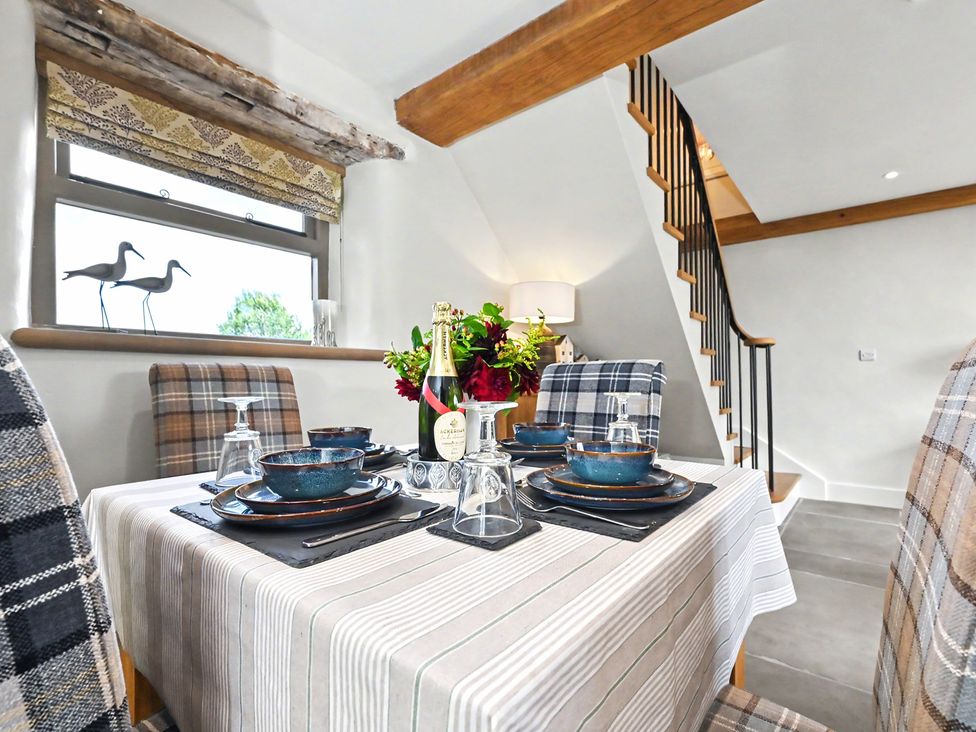 A dining area with a set table at Lane House Farm Barn Butterton