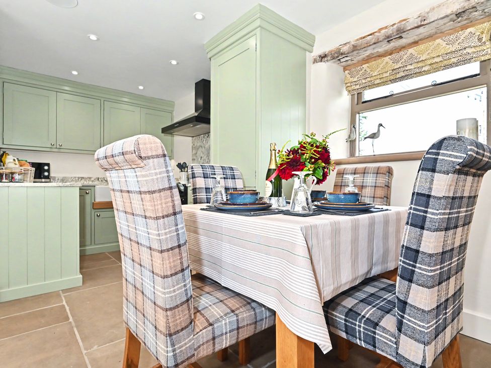 A kitchen with a table and chairs at Lane House Farm Barn Butterton