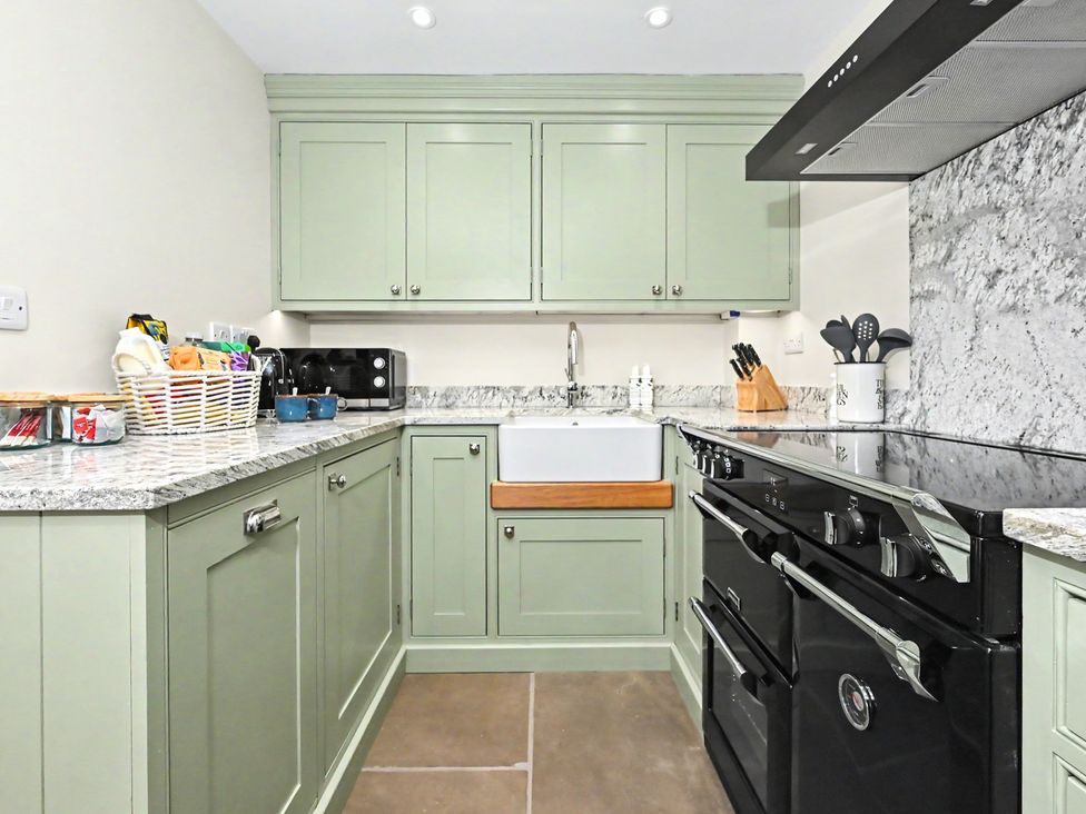 A kitchen with cabinets and an oven at Lane House Farm Barn in Butterton