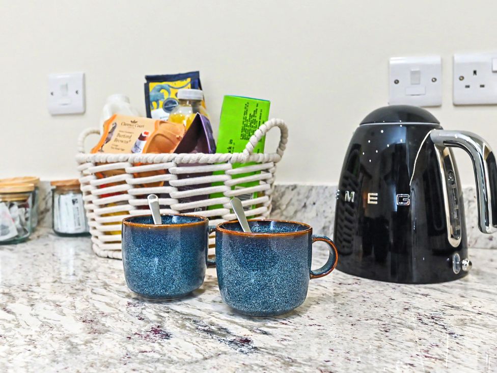 A kitchen with mugs and a kettle at Lane House Farm Barn Butterton