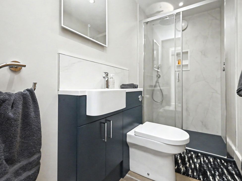 A bathroom with a sink, toilet, and shower at Lane House Farm Barn Butterton