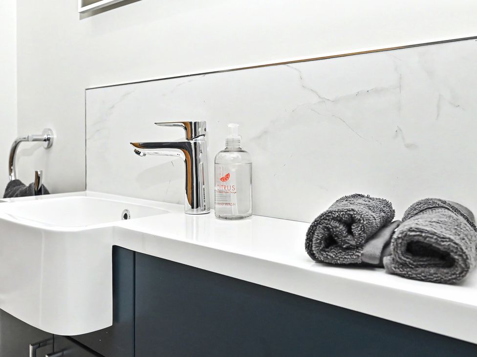 A bathroom with a sink and soap dispenser at Lane House Farm Barn Butterton