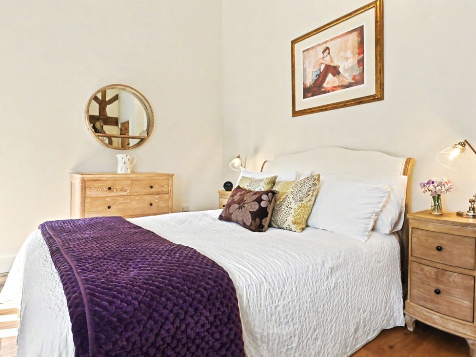 A bedroom with a bed and bedside tables at Lane House Farm Barn in Butterton