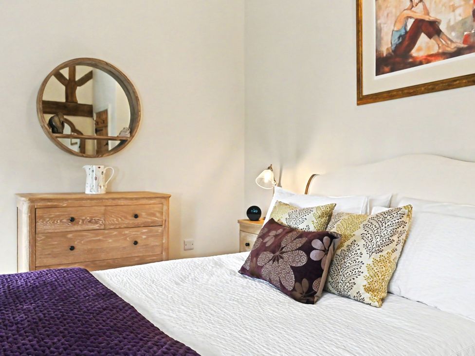 A bedroom with a bed, pillows and dresser at Lane House Farm Barn in Butterton