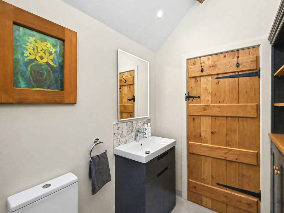 A bathroom with a sink and mirror at Lane House Farm Barn Butterton