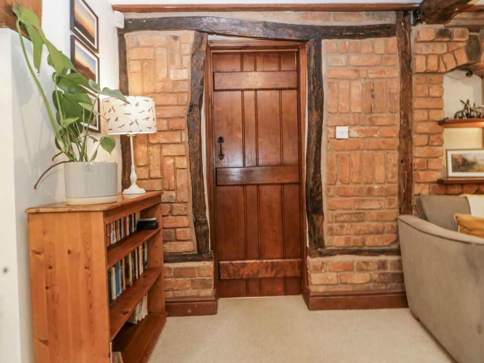 A living room with a door and bookshelf at Magpie Cottage in Worcester