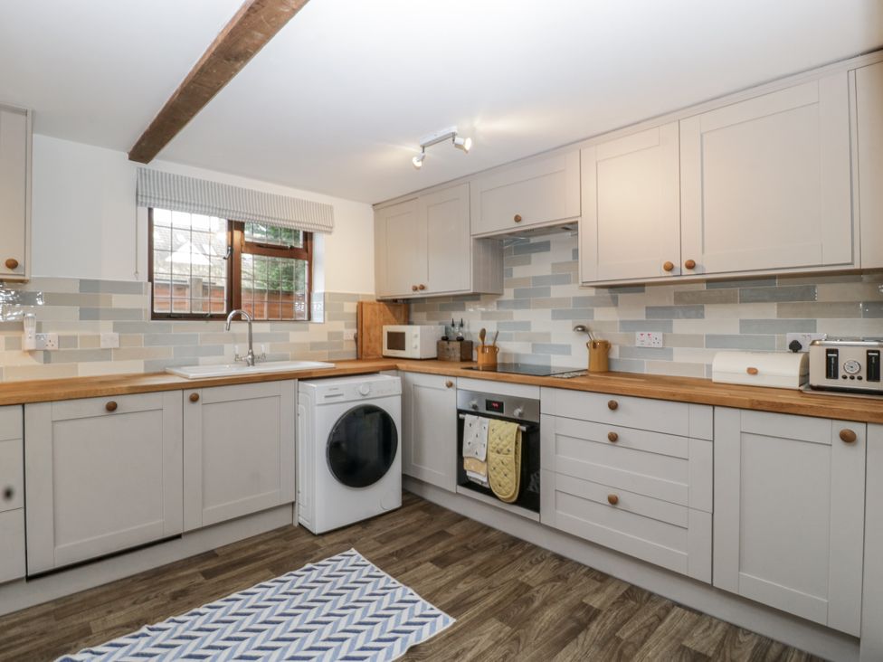 A kitchen with cabinets and appliances at Magpie Cottage in Worcester
